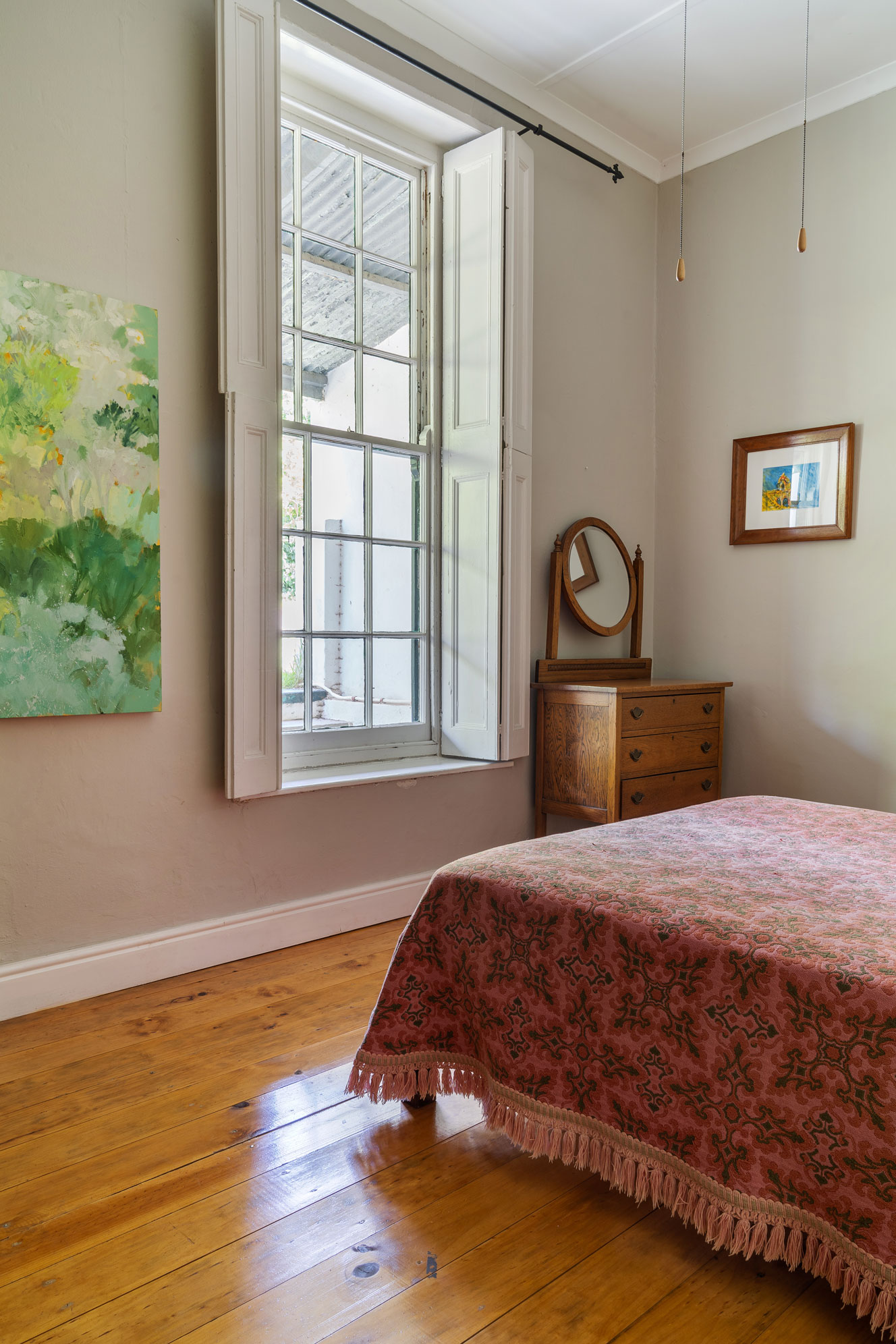 Pink and green bedroom with green art on the walls