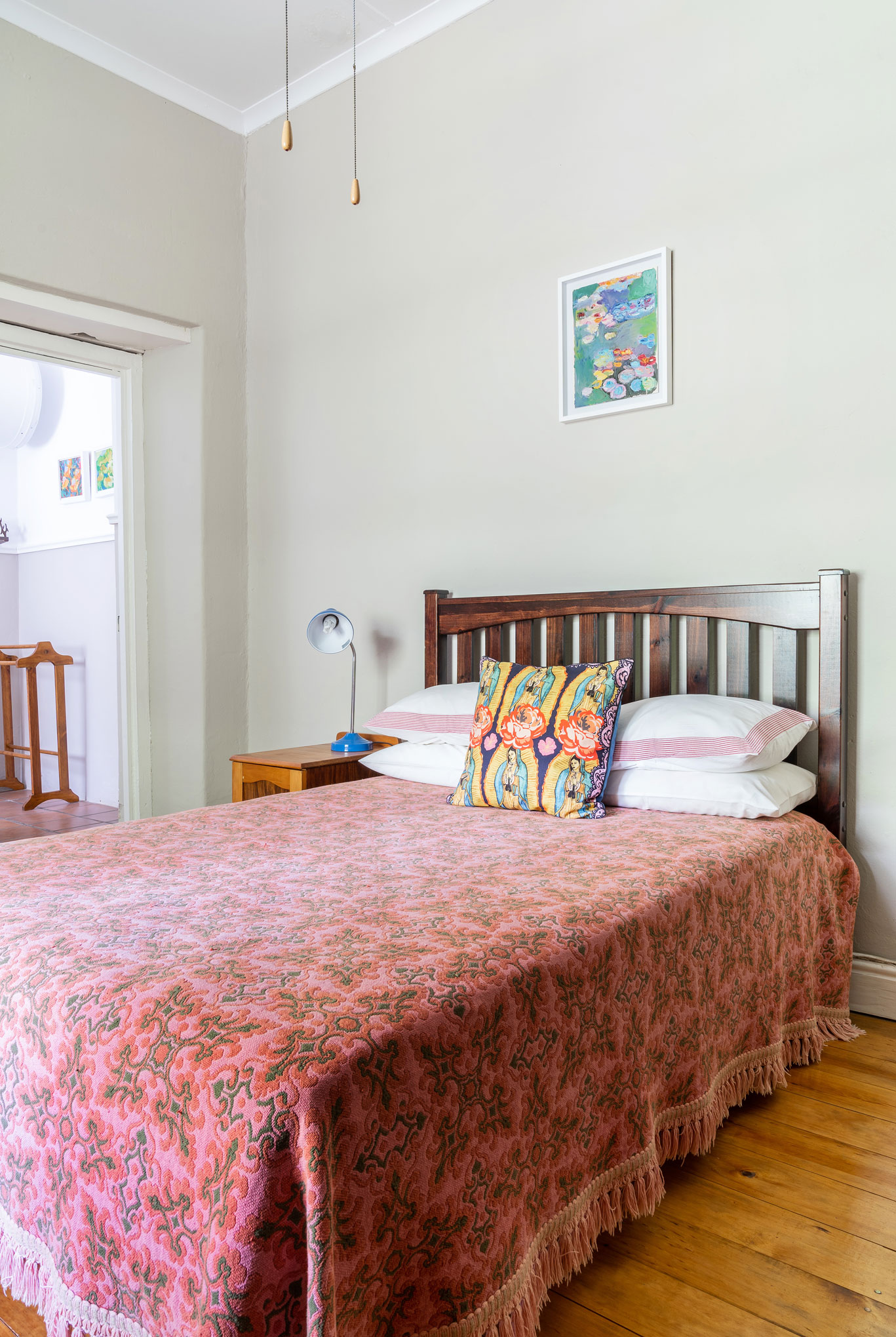 Pink and green bedroom with a mix of bold patterns and graphic, illustrative fabrics