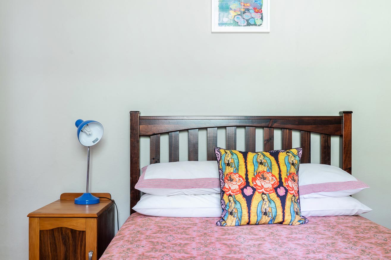 Pink and green bedroom with a mix of bold patterns and graphic, illustrative fabrics